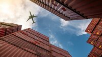 Airplane Flying Above Containers