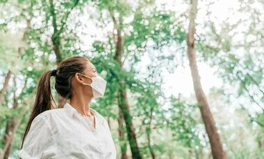 Woman wearing mask in forest