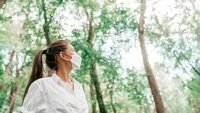 Woman wearing mask in forest